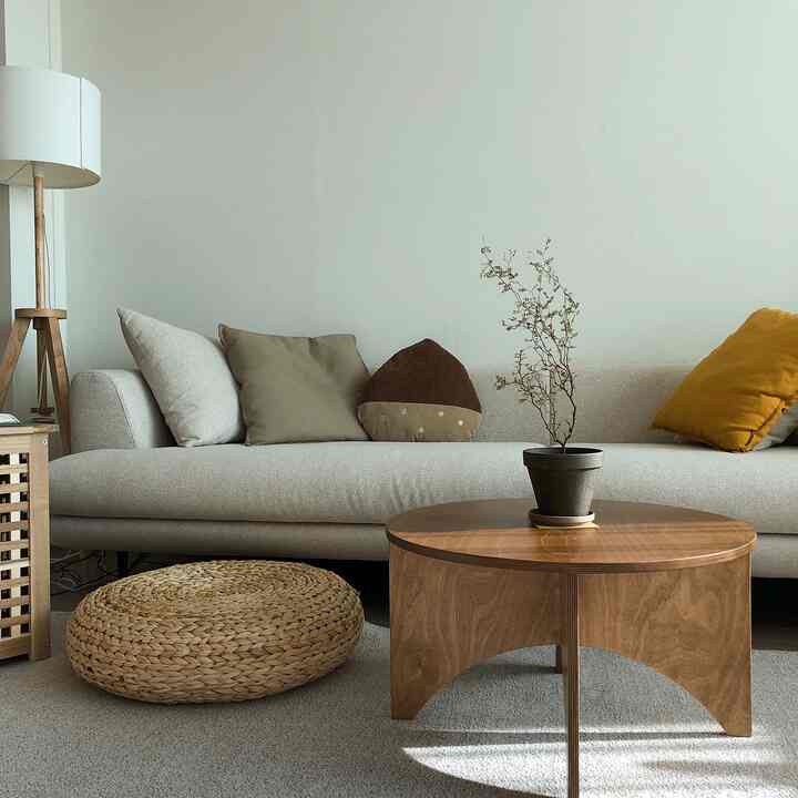 Natural toned living room featuring beige sofa and wooden coffee table creating a simple and cozy atmosphere