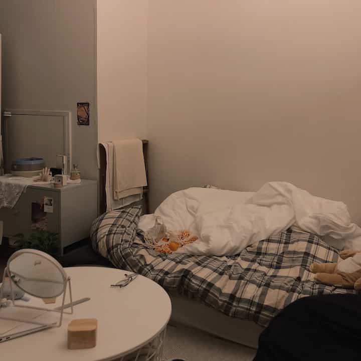 White and gray toned 6-pyeong officetel bedroom featuring low bed and bean bag with a compact, cozy atmosphere