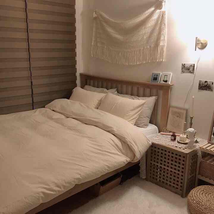 Warm beige bedroom featuring a wooden bed and rattan accessories, creating a natural and cozy atmosphere