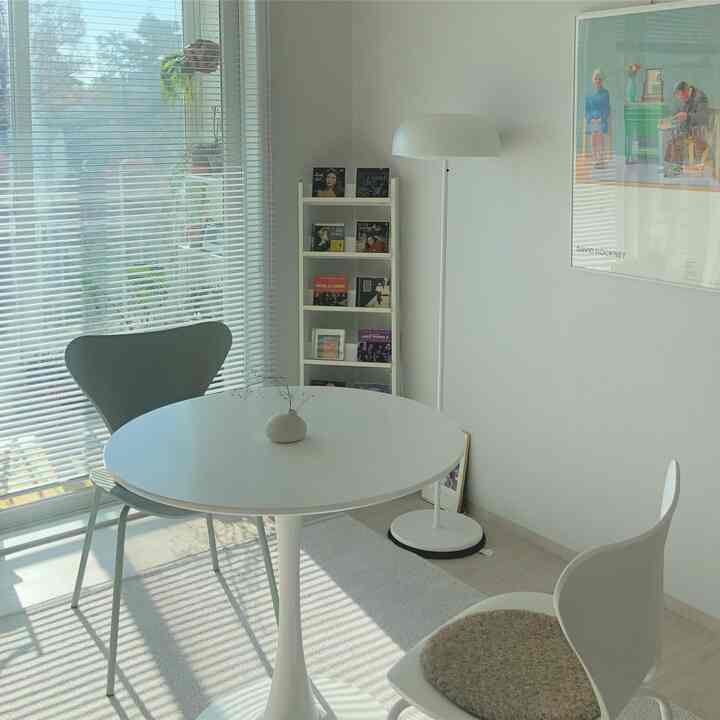 Bright white and natural tones define a round table living room with a simple, clean atmosphere