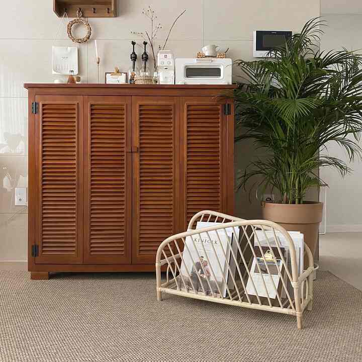 温かみのあるブラウンの木目調ルーバーキャビネットが配置されたナチュラルスタイルの居心地の良い室内空間