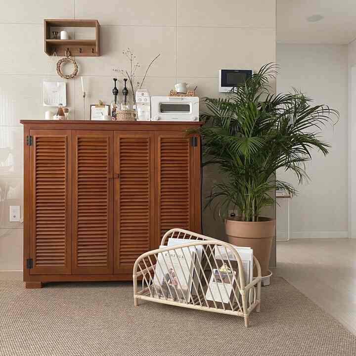 Cozy home cafe space featuring natural wood tones, beige rug, and a large green plant