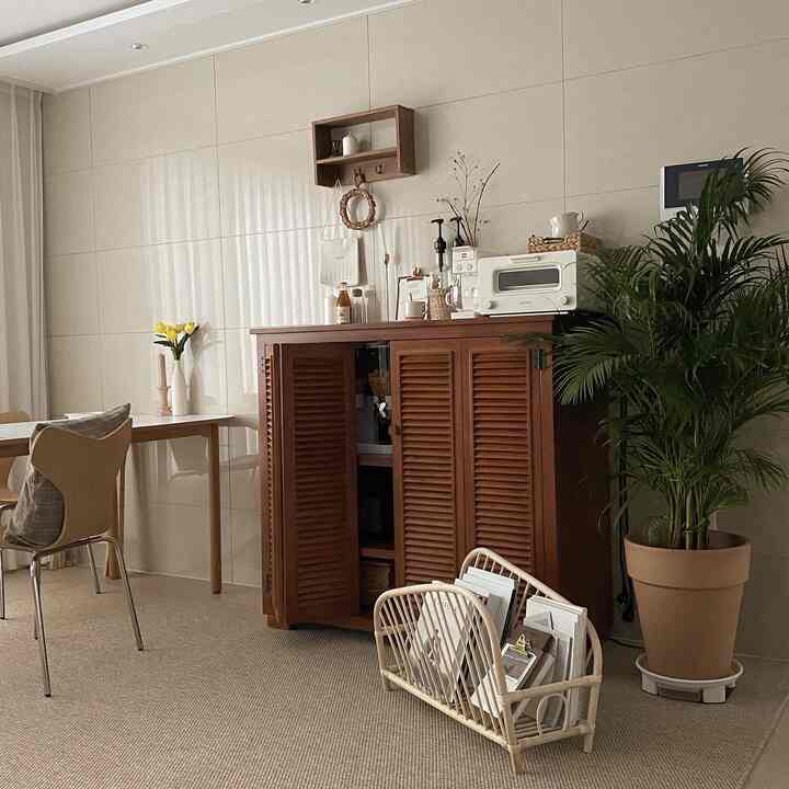 Ivory toned living room featuring natural wood furniture and green plant with a cozy home cafe vibe