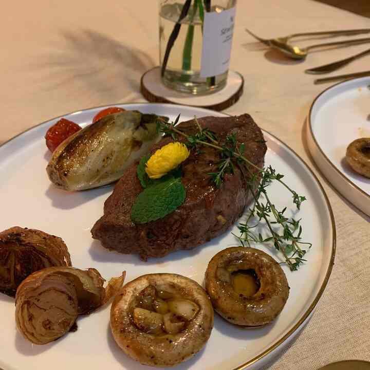Natural color and white gold dining table featuring a steak serving dish and cutlery set for a cozy home party atmosphere