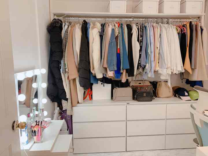 White-toned walk-in closet featuring wardrobe racks and drawer units with an organized self-dressing room vibe