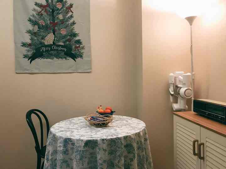 An ivory-tone small dining area featuring a vintage radio and blue floral tablecloth