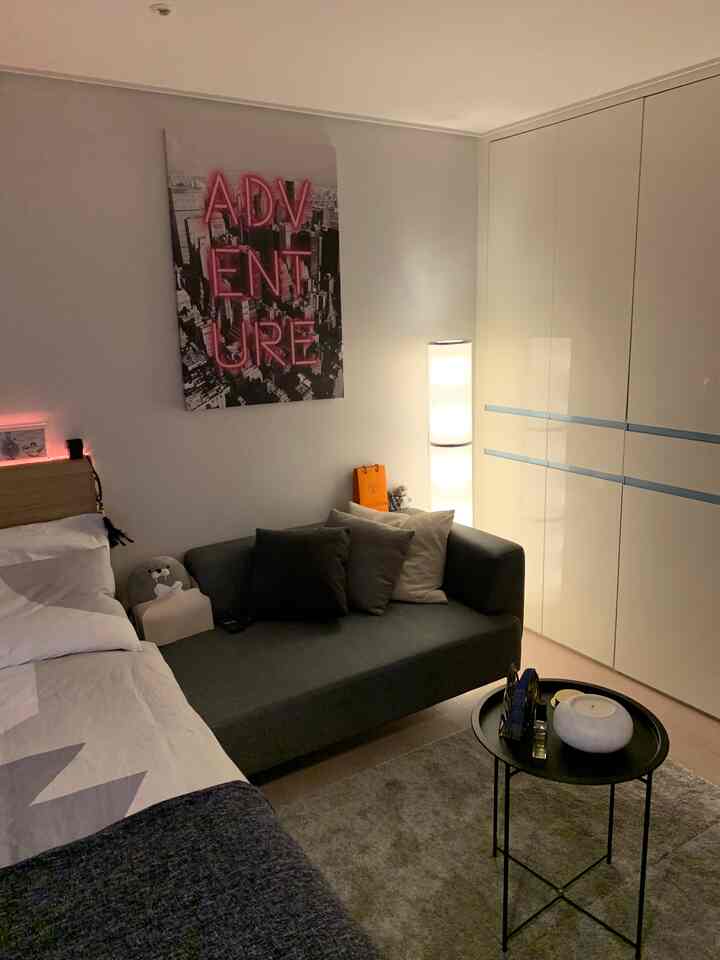 Gray and white toned 8-pyeong studio apartment featuring sofa and bed with clean, hotel-like atmosphere