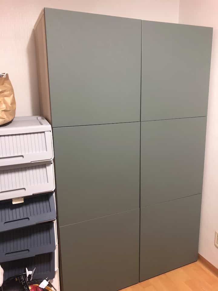 Simple space featuring large storage cabinet with light green doors and brown wooden frame