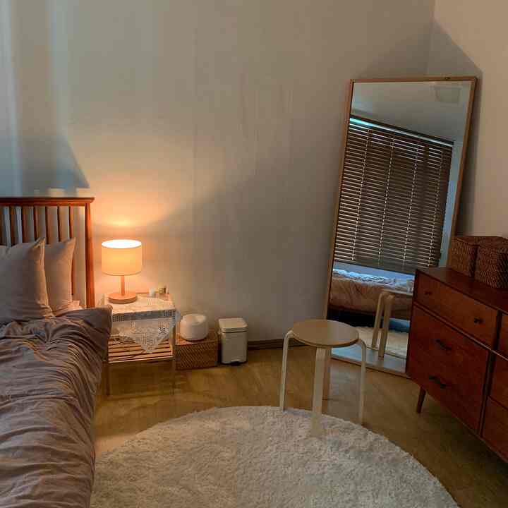 温かみのある木目調とライトブラウンの家具が配置されたシンプルで自然な雰囲気の寝室