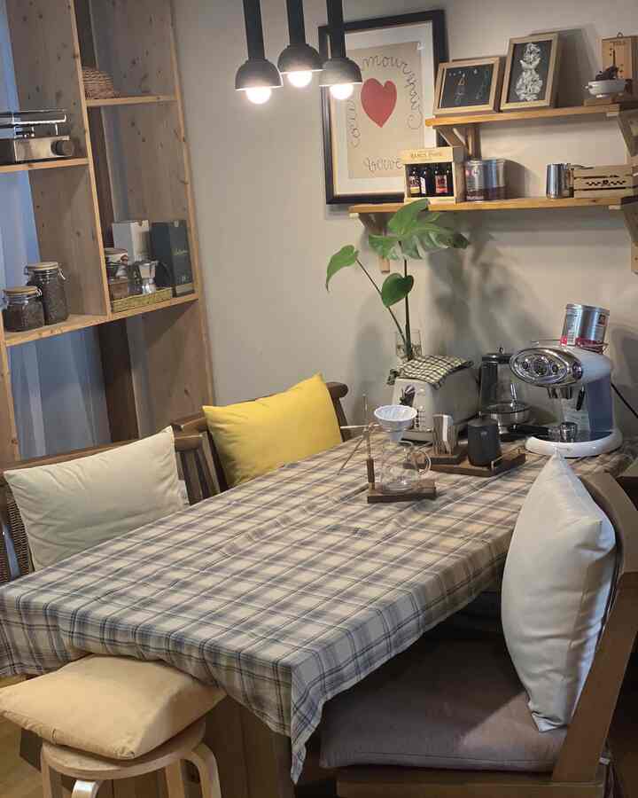 Wood-toned kitchen featuring a vintage check tablecloth, home cafe accessories, and a cozy atmosphere