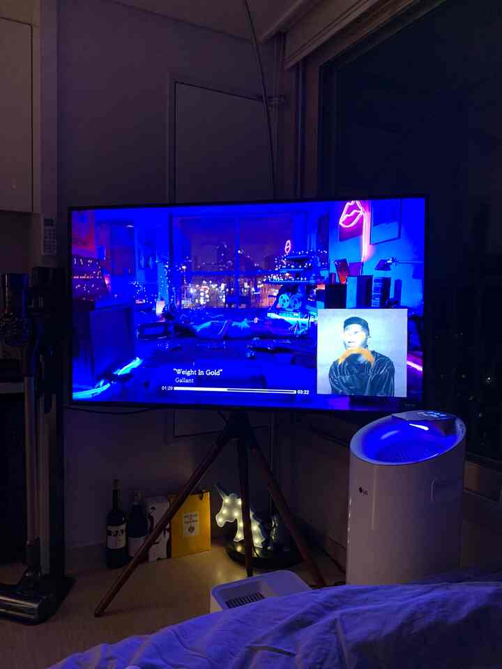 Dark tone and blue hues dominate this studio apartment featuring a large TV stand and air purifier in a modern setting