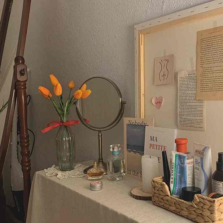 Beige-toned vanity with vase, mirror, and canvas creating cozy vintage ambiance