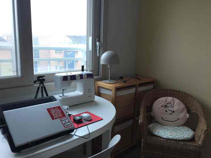White table and rattan chair in a small room workspace designed for remote work and crafting
