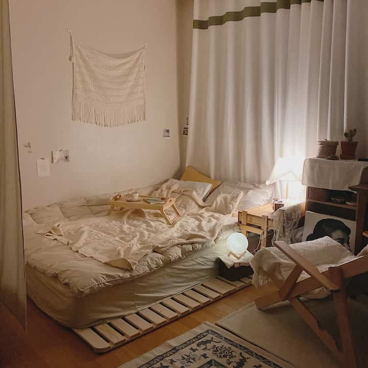 Warm beige and ivory toned bedroom featuring wooden furniture and fabric elements creating a cozy atmosphere
