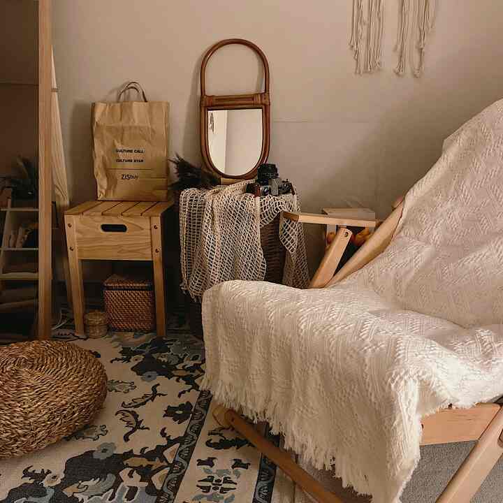 Cozy living room with natural wood tones and rattan accents, featuring a white fabric-covered armchair as the focal point