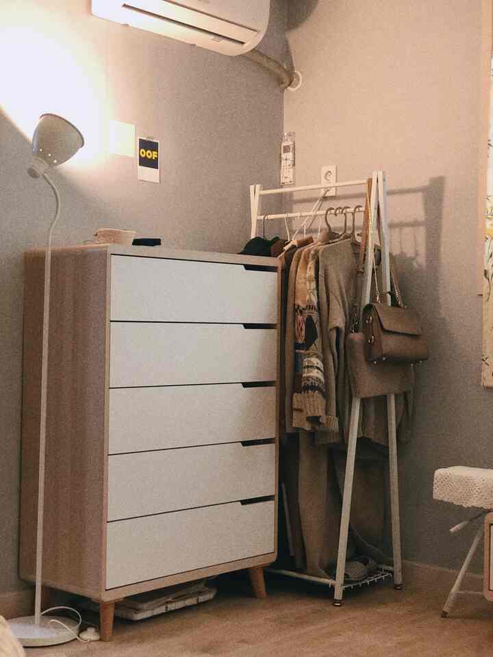 ホワイトとブラウンの色調が特徴の狭い部屋、チェストとハンガーで整頓されたナチュラルなインテリア