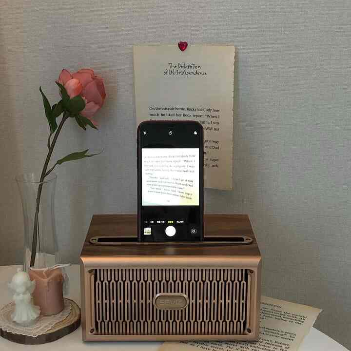 木目調のヴィンテージ風ブルートゥーススピーカーと花瓶、キャンドルが置かれた雰囲気のあるインテリア