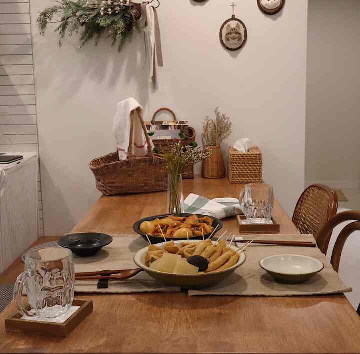 Dining room with soft wood tones and beige colors, featuring a wooden dining table and rattan baskets in a natural setting