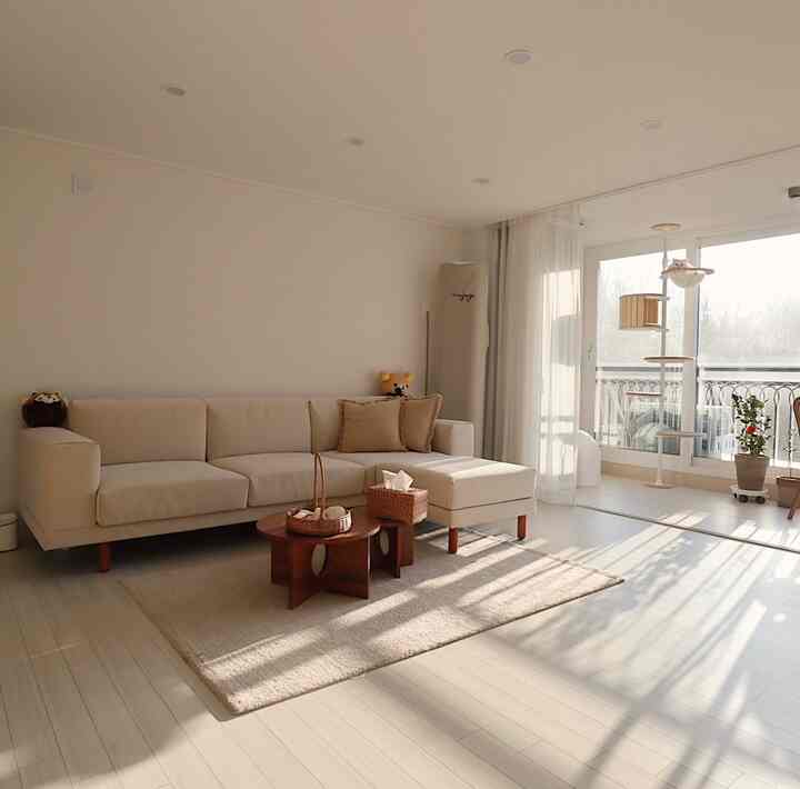 Ivory-toned natural living room featuring beige wooden tables and sofa with warm sunlight-filled atmosphere