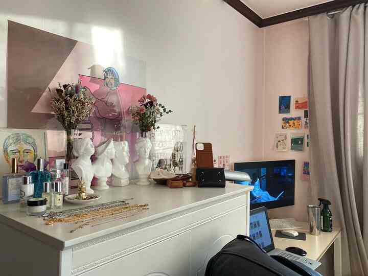 Natural-toned small room in beige and white, featuring a low junior wardrobe with organized accessories and a cozy home office setup