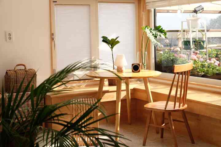 木目調と白が調和した居心地の良いダイニング、自然光と植物が配された落ち着いた雰囲気のインテリア