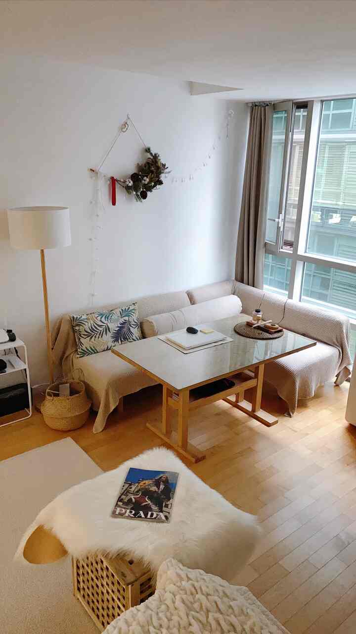 White and beige toned living room featuring beige sofa, wooden table, and natural decor creating a cozy atmosphere