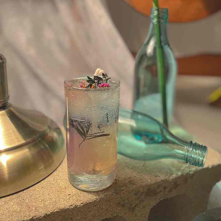Natural color toned workspace featuring a transparent flower-embedded candle on a stone tray with a cozy atmosphere