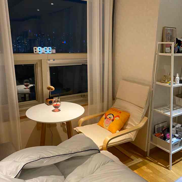 白と木目調のリビング、アームチェアと丸テーブルが配置された雰囲気あるおうちカフェ空間