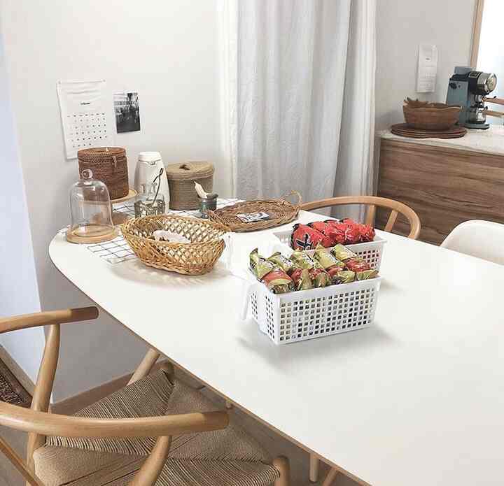 White and brown toned kitchen dining space featuring natural furniture and storage items in a clean interior