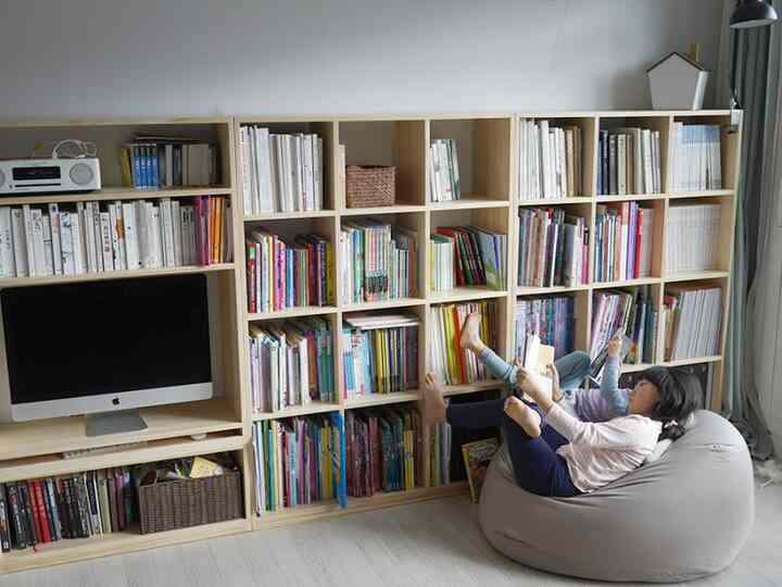 Bright white and wood tone study space with children reading on a bean bag chair