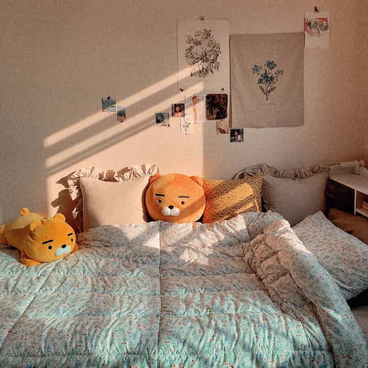 Warm beige and white toned bedroom featuring floral bedding and cushions creating a cozy vintage atmosphere