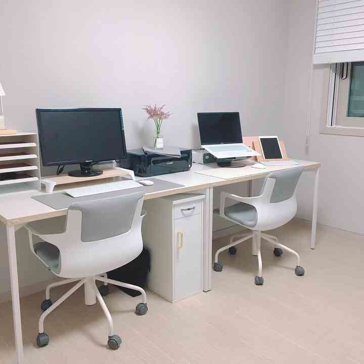 White and gray toned two-person home office with desks and office chairs arranged neatly