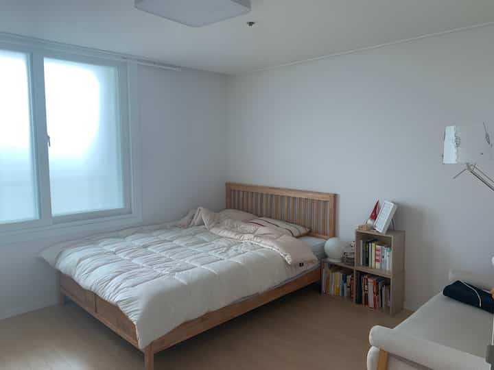 Natural style bedroom with bright white walls and wooden bed, creating a warm and cozy atmosphere