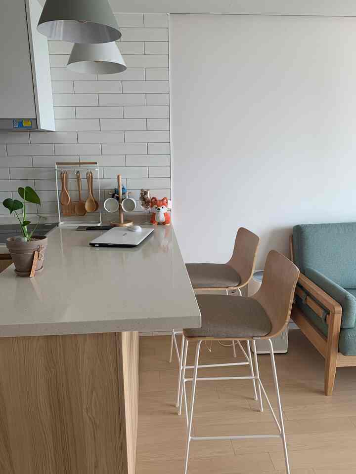 Natural-toned kitchen and living space featuring a wood kitchen island and Sidiz bar stools with a cozy atmosphere
