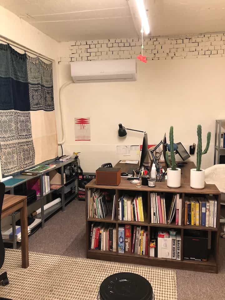 White and beige toned home office featuring bookshelves and computer desks in a compact workspace