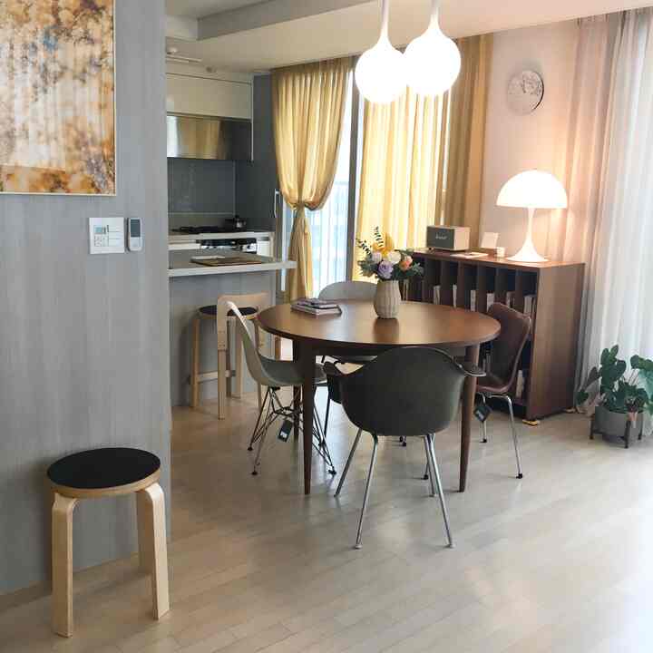 Dining room with beige curtains and wood tone dining table, with natural lighting creating cozy atmosphere
