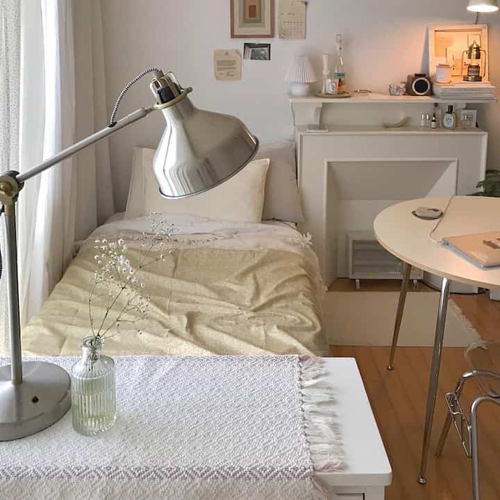 柔らかなベージュと白のトーンのワンルーム寝室、シンプルで自然な雰囲気のあるインテリア