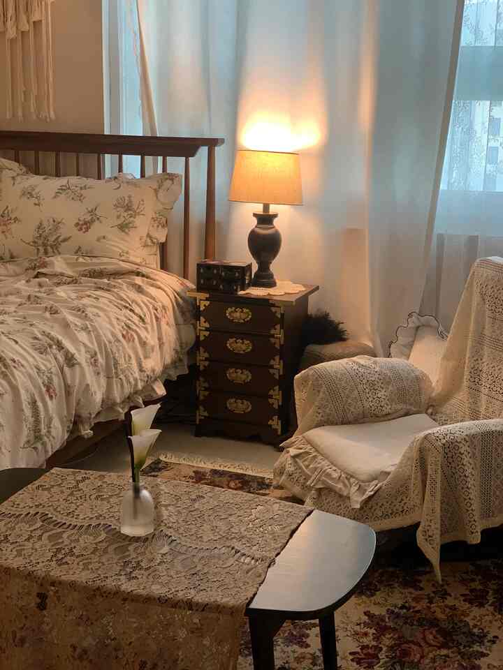 Calm ivory-toned bedroom featuring lace fabrics, floral bedding, and vintage-style furniture creating a cozy ambiance