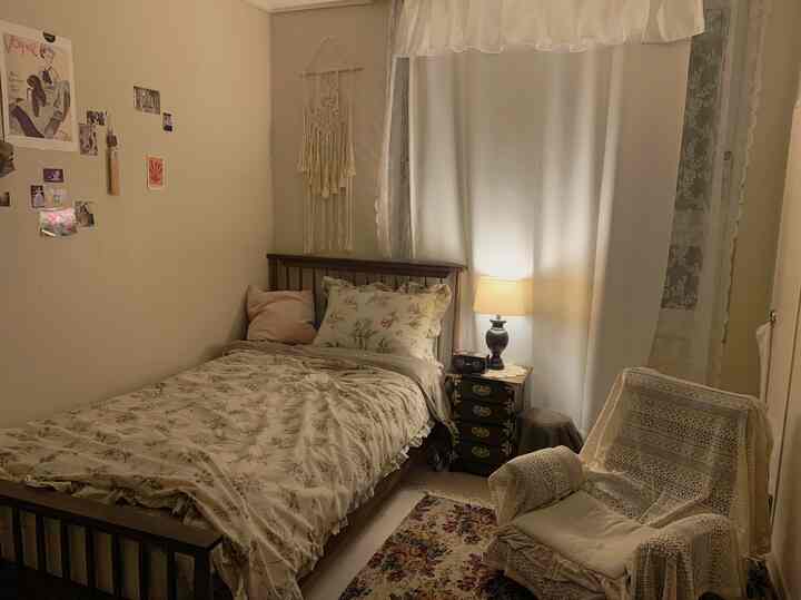 暖かい茶色のトーンのワンルーム寝室、ヴィンテージ家具と柔らかい黄色照明の雰囲気あるインテリア