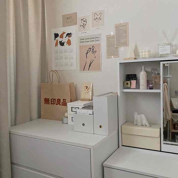Small white and natural toned room featuring a vanity, dresser, and wall decor with a clean and simple atmosphere