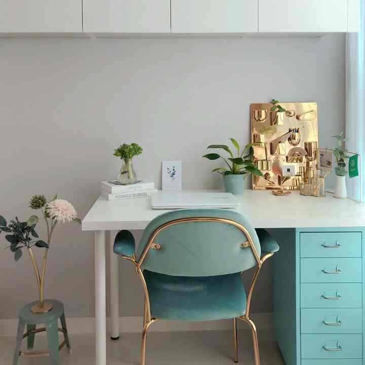 Modern home office with mint and gold accents, featuring a clean desk and storage cabinet in an organized workspace