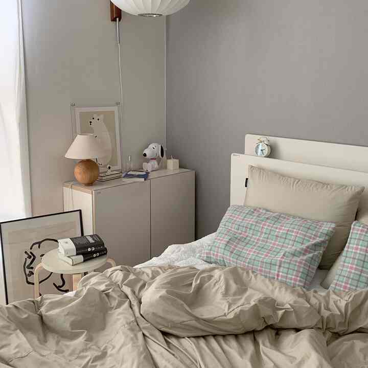 Beige and gray toned bedroom featuring bed with pillows and duvet, creating a cozy natural atmosphere