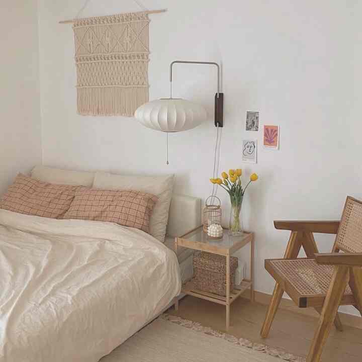 Beige-toned bedroom featuring bed, nightstand, and rattan chair arranged in a cozy natural style setting