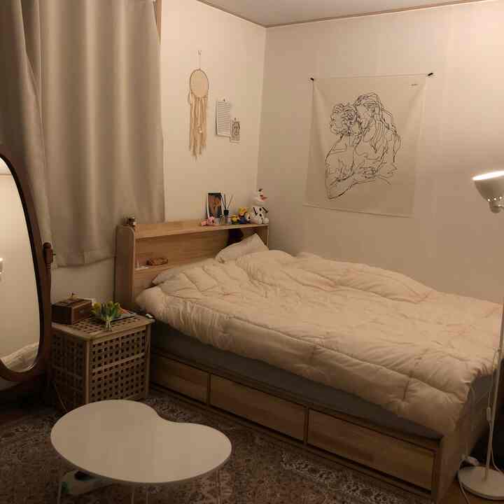 Warm wood tones and natural bedroom featuring a wooden bed, nightstand, and full-length mirror creating a cozy space