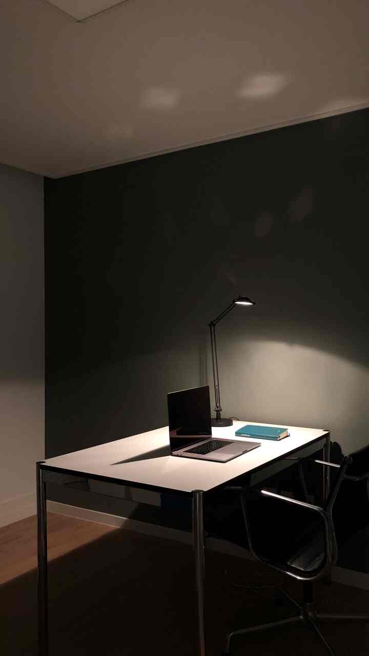 Small home office space in white and black tones featuring a desk and office chair with a simple atmosphere