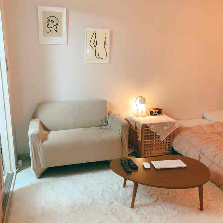 Soft beige and white toned bedroom featuring sofa, bed, and nightstand arranged for a cozy atmosphere