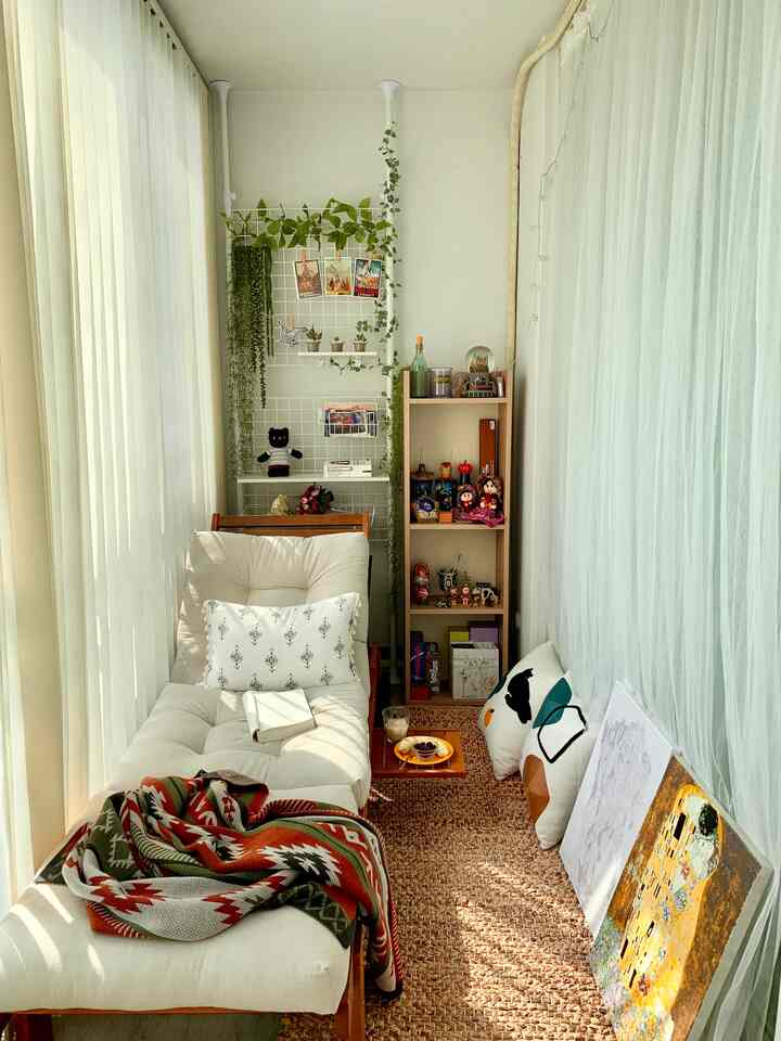 Beige and natural toned veranda featuring a cozy sofa, plants, and framed artwork creating a warm relaxation space
