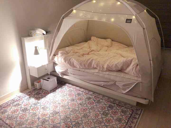 White and beige toned small 4.5-tatami bedroom featuring a bed covered with a heating tent and a mini vanity, creating a cozy resting space
