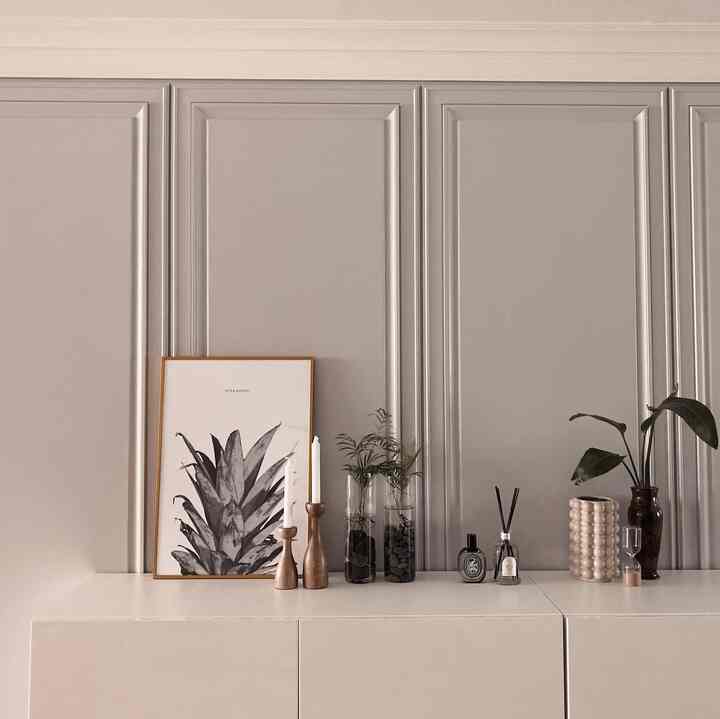 Natural tone living room featuring a beige cabinet with picture frame, aquatic plants, and diffusers creating a clean interior