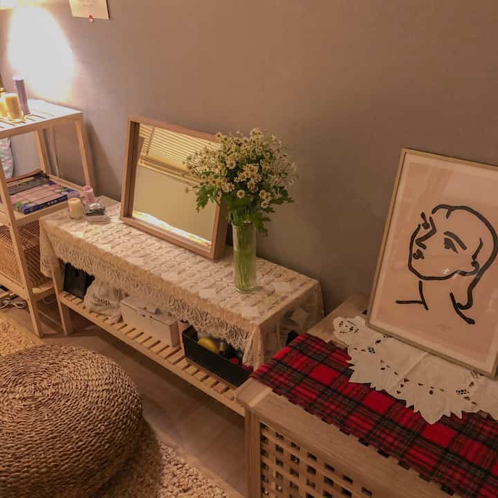 Warm wood tones and natural color living room featuring a storage bench with vase and framed artwork creating a cozy atmosphere